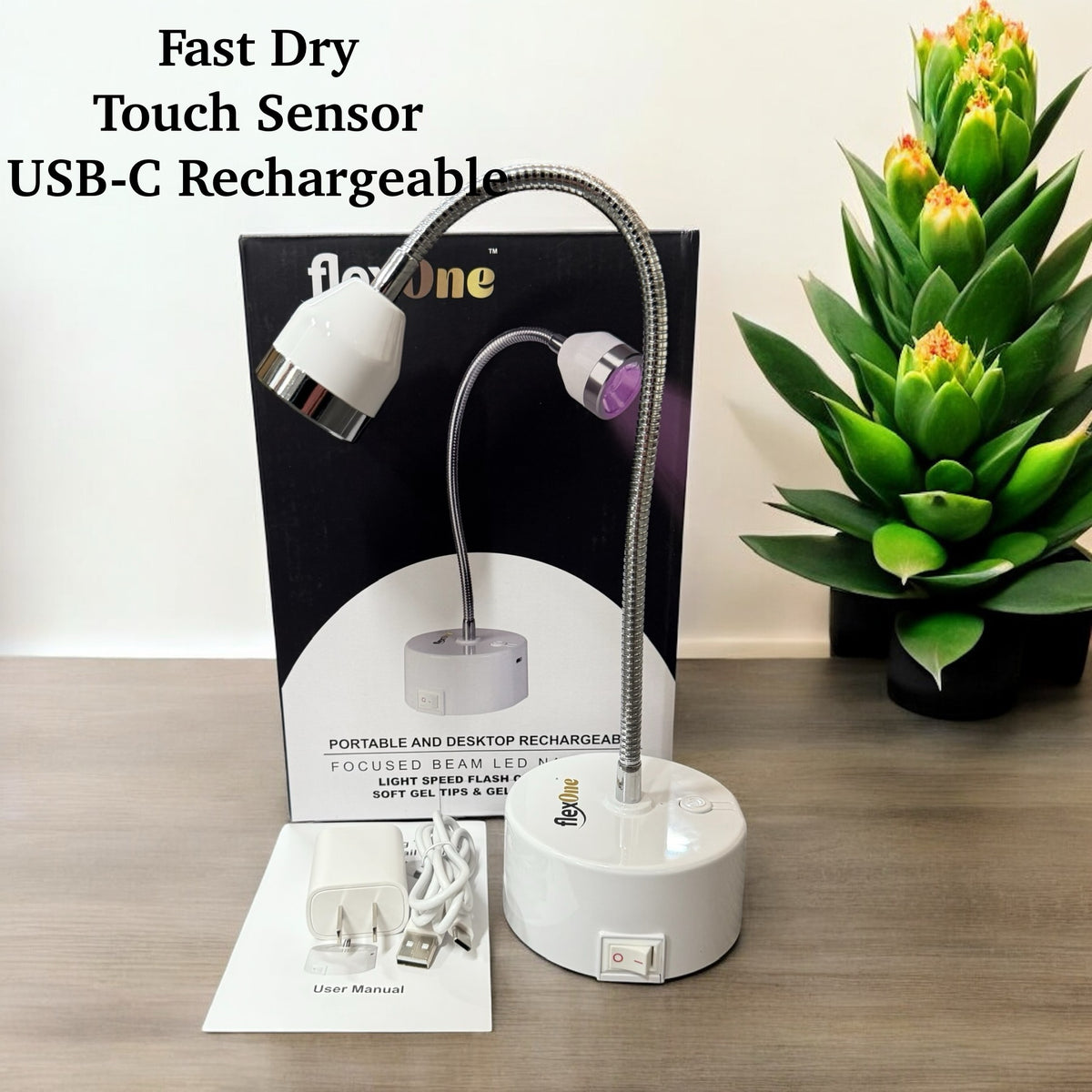 A Gel X UV light with a touch sensor and USB-C rechargeable base, displayed alongside its packaging and a USB cable, on a wooden surface with a potted plant in the background.