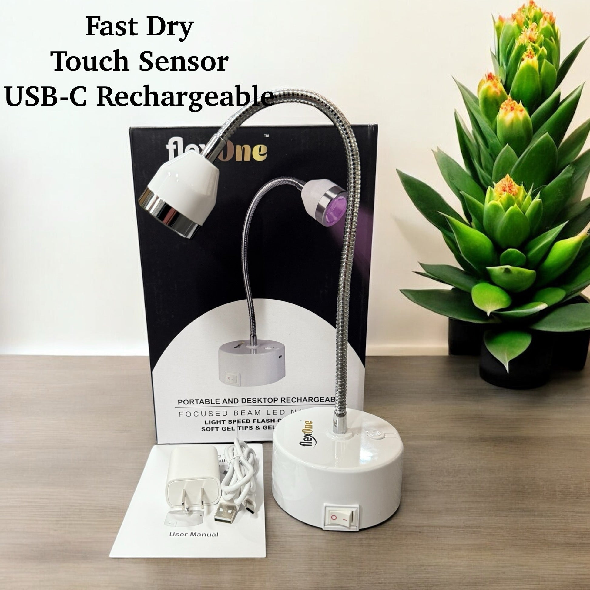 A Gel X UV light with a touch sensor and USB-C rechargeable base, displayed alongside its packaging and a USB cable, on a wooden surface with a potted plant in the background.